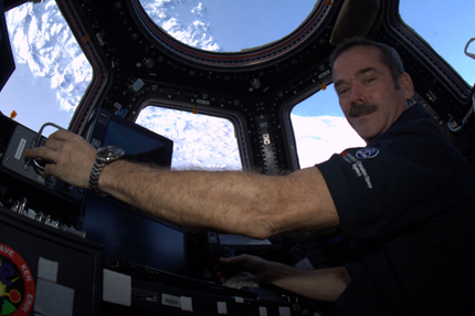 Hadfield in the cupola at the helm of the Canadarm2