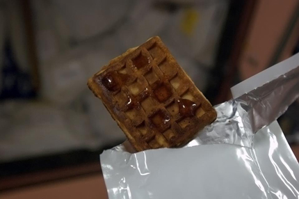 A photo of a weightless waffle with maple syrup