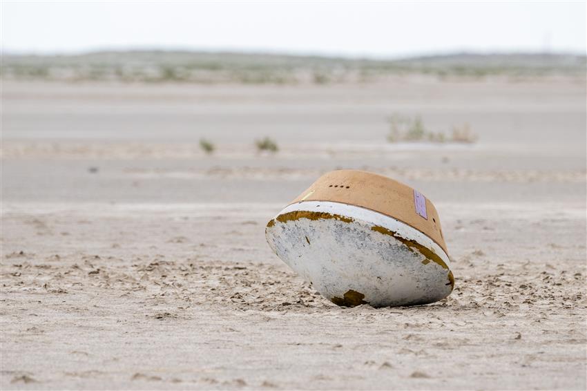 Une capsule est sur le sol d’un grand désert.
