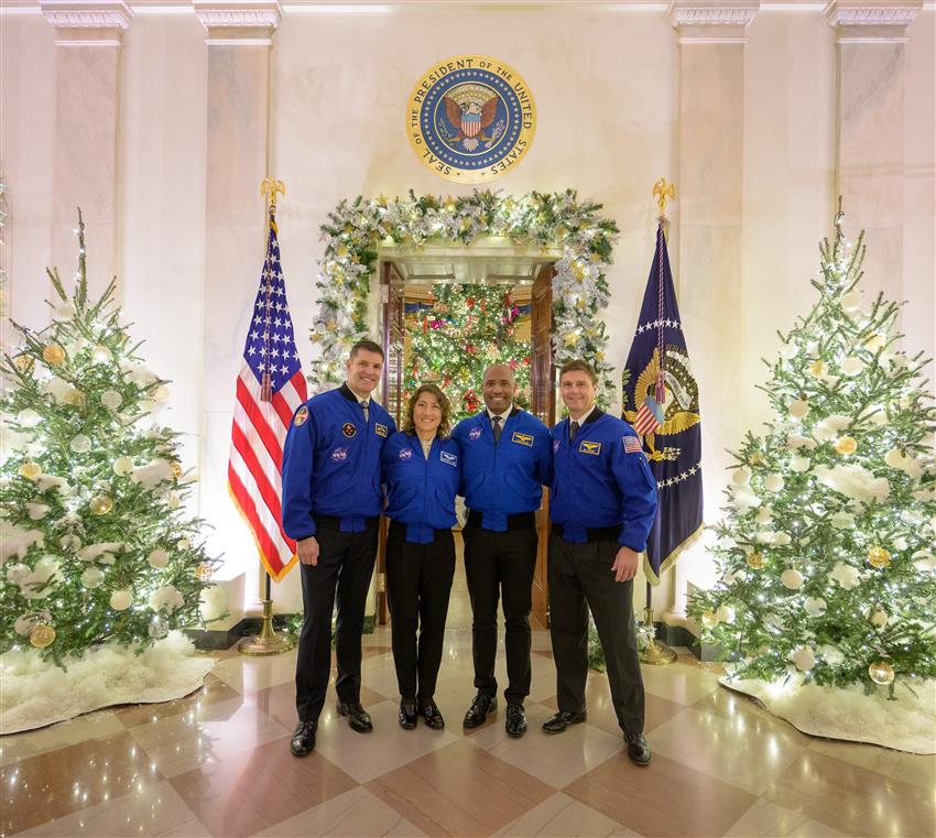 Les quatre astronautes dans une pièce décorée pour Noël.