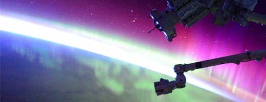 Image of an aurora and Canadarm2 from space