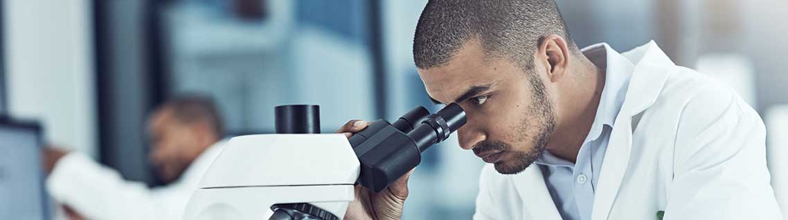 Man uses a microscope in a laboratory