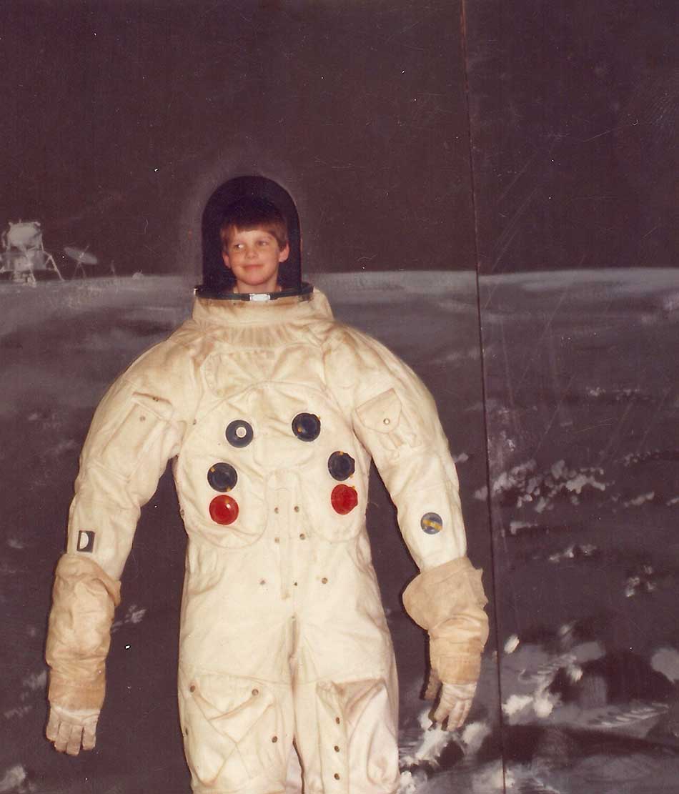 Young Jeremy Hansen in a mock-up spacesuit