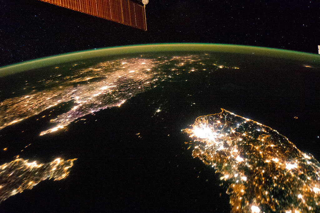 North Korea appears almost fully blacked out between China (top left) and South Korea (bottom right) in this night image of the Korean Peninsula taken by an astronaut aboard the International Space Station 2014. The capital city, Pyongyang, is the dot of light visible in the center. The countries' borders are so dark they are almost indistinguishable from the Yellow Sea and Sea of Japan on either side. (Credit: NASA)