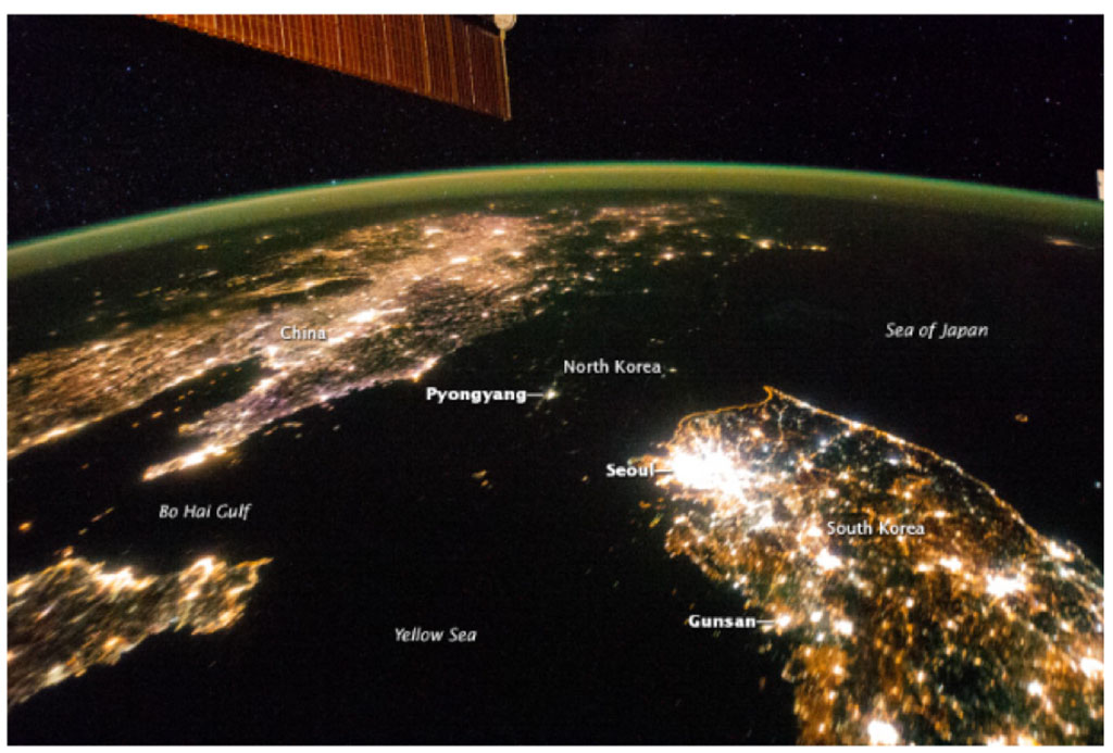 North Korea appears almost fully blacked out between China (top left) and South Korea (bottom right) in this night image of the Korean Peninsula taken by an astronaut aboard the International Space Station 2014. The capital city, Pyongyang, is the dot of light visible in the center. The countries' borders are so dark they are almost indistinguishable from the Yellow Sea and Sea of Japan on either side. (Credit: NASA)