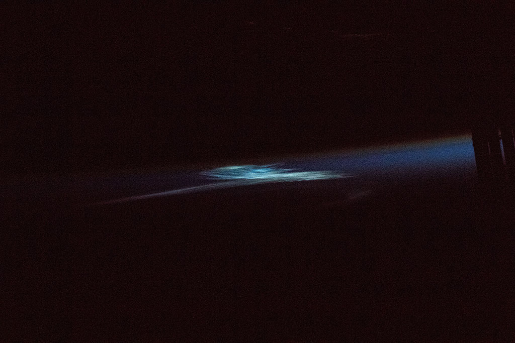 Noctilucent clouds are the highest clouds in Earth's atmosphere. They consist of ice crystals and are visible only when illuminated by sunlight from below the horizon while the lower layers of the atmosphere are in Earth\'s shadow. This photo was taken by David Saint-Jacques from the International Space Station. (Credit: Canadian Space Agency/NASA)