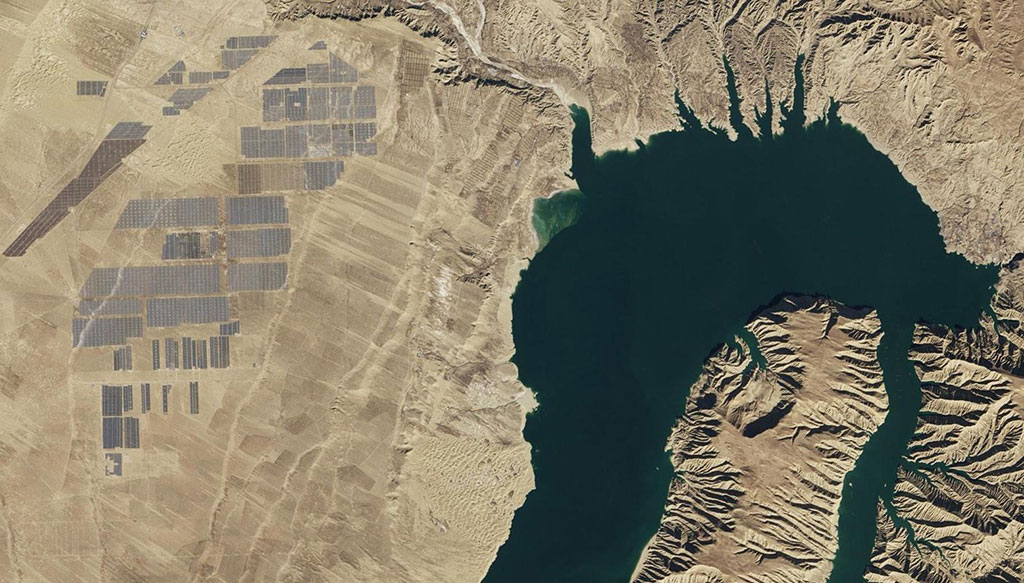 A hydroelectric dam is connected to a solar farm at Longyangxia, on the Tibetan plateau in China, one of the largest photovoltaic power stations in the world with four million panels. (Credit: NASA Earth Observatory)