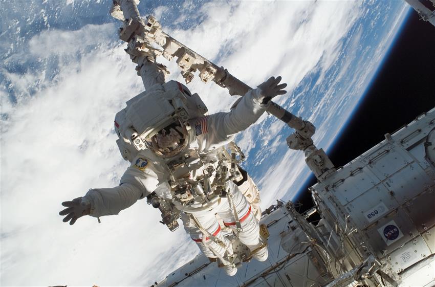 NASA astronaut Rick Linnehan, anchored to the end of Canadarm2