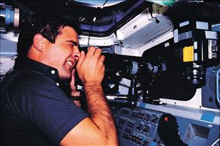 Marc Garneau menant une expérience à bord de la navette Challenger durant la mission STS-41G