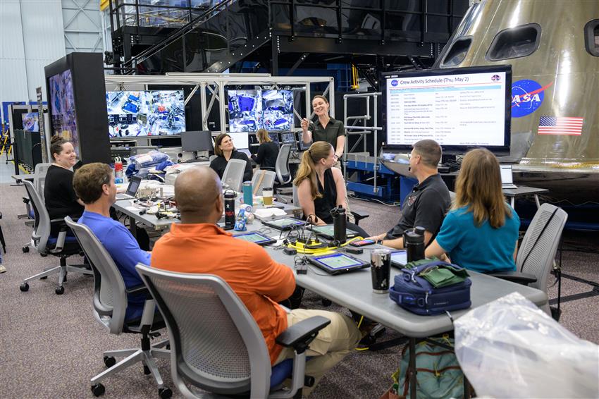 The Artemis II crew listen to an instructor.
