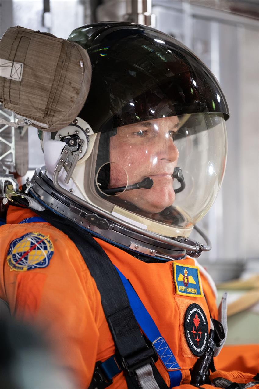 Close-up of Jeremy in a spacesuit with his helmet on.