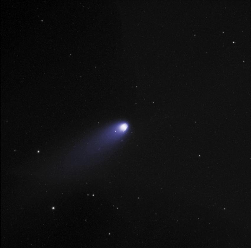 A bright white dot in the center represents the comet, surrounded by smaller dots and a glowing halo.