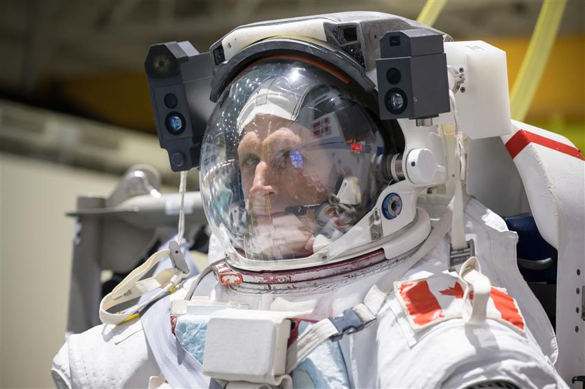 A close-up of Joshua wearing his spacesuit helmet.