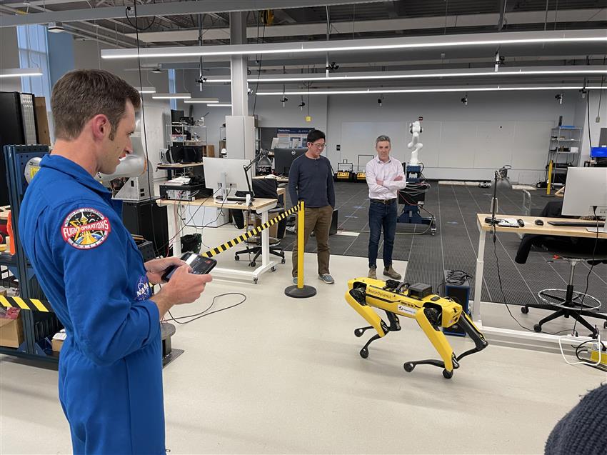 Joshua holds a controller to operate a four-legged robot.