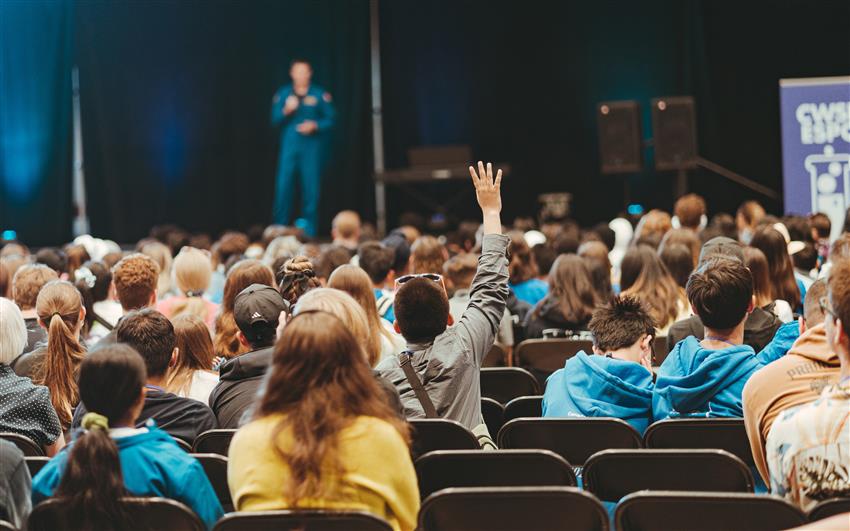 Jeremy is standing on stage in front of a crowd of teenagers.