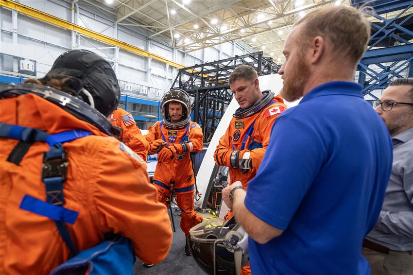 The crew putting on their spacesuit sit outside the Orion mockup.