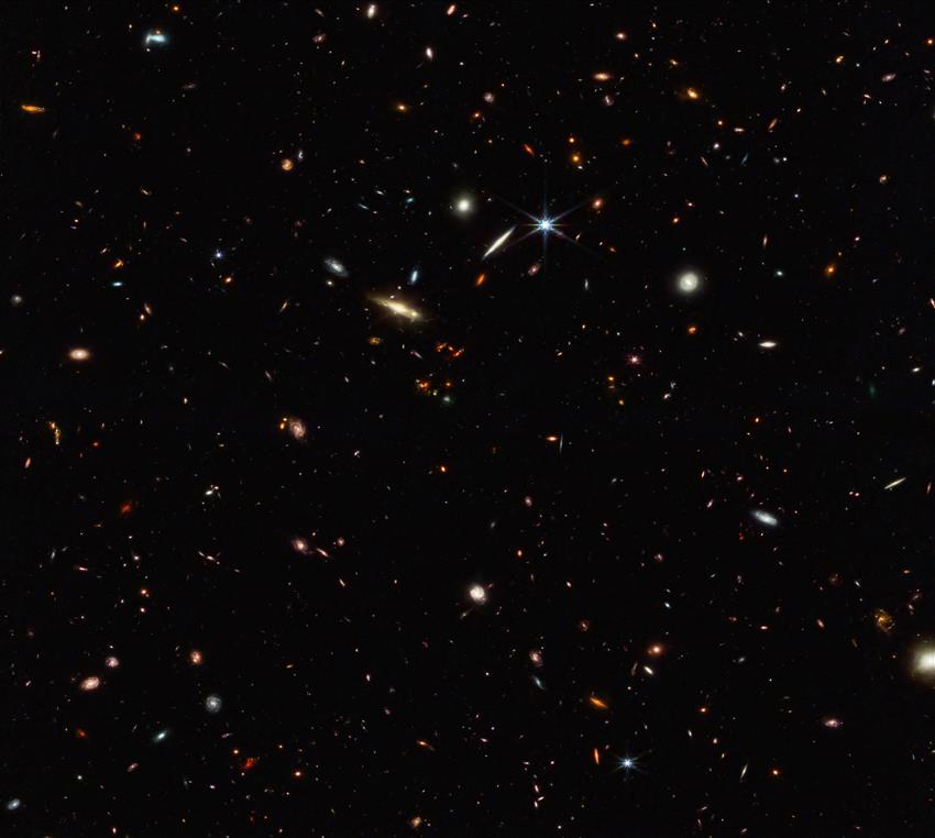 A black field speckled with a variety of galaxies of numerous shapes and sizes.