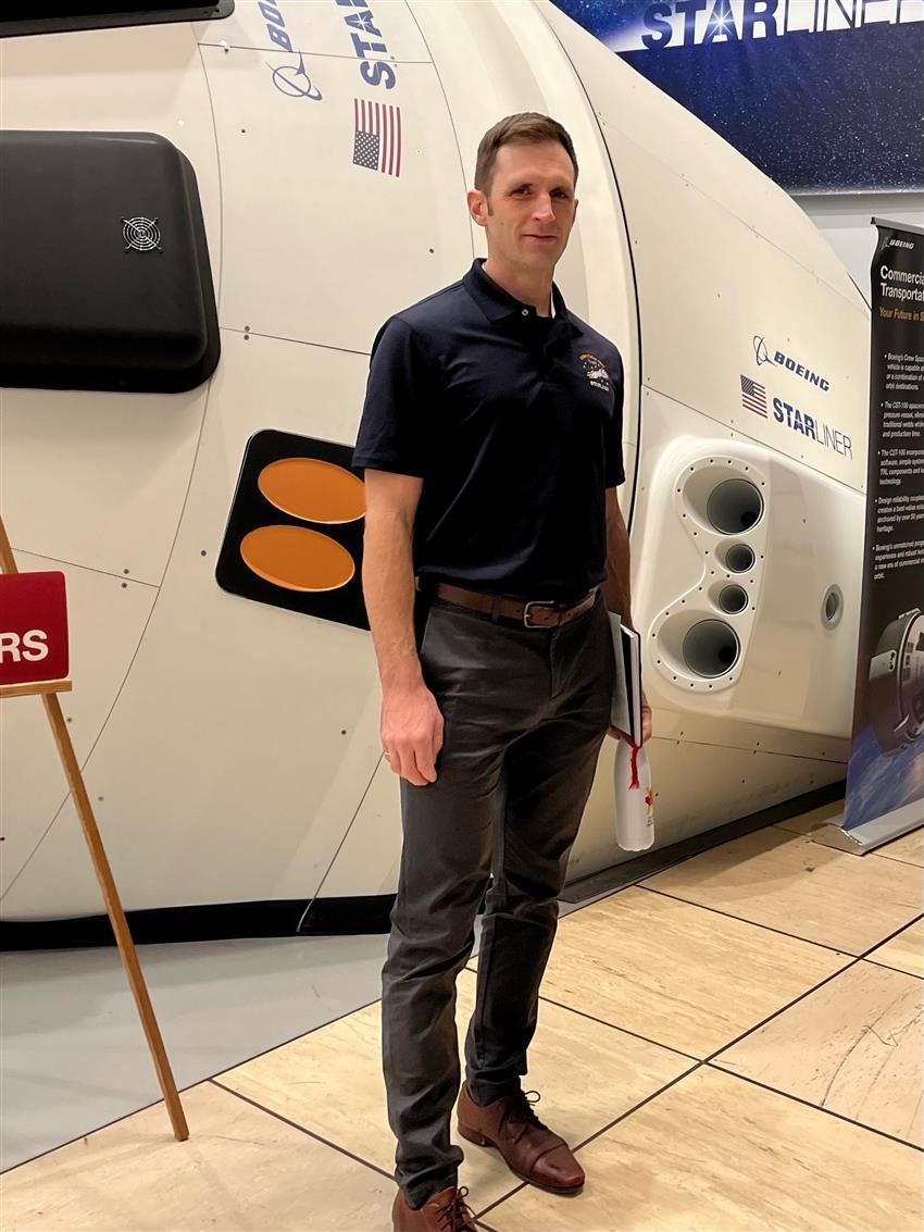 Joshua in front of the Starliner simulator.