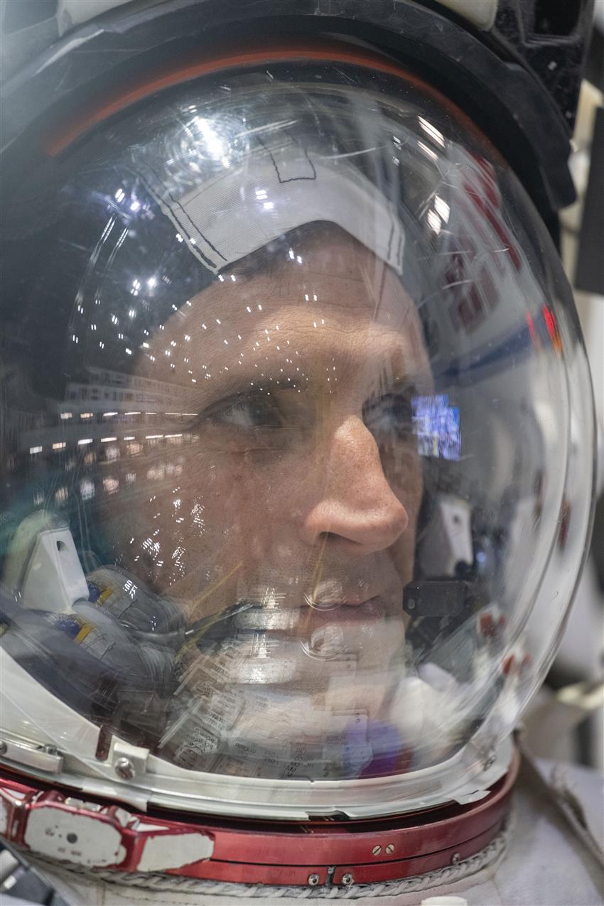 A close-up of Joshua wearing his spacesuit helmet.