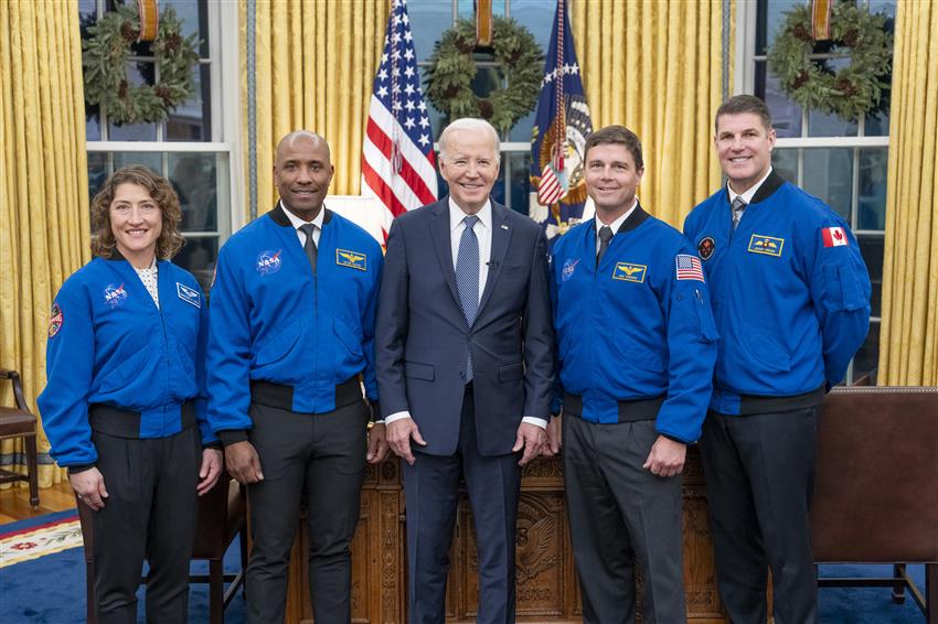 The four astronauts pose with Joe Biden in the Oval Office.